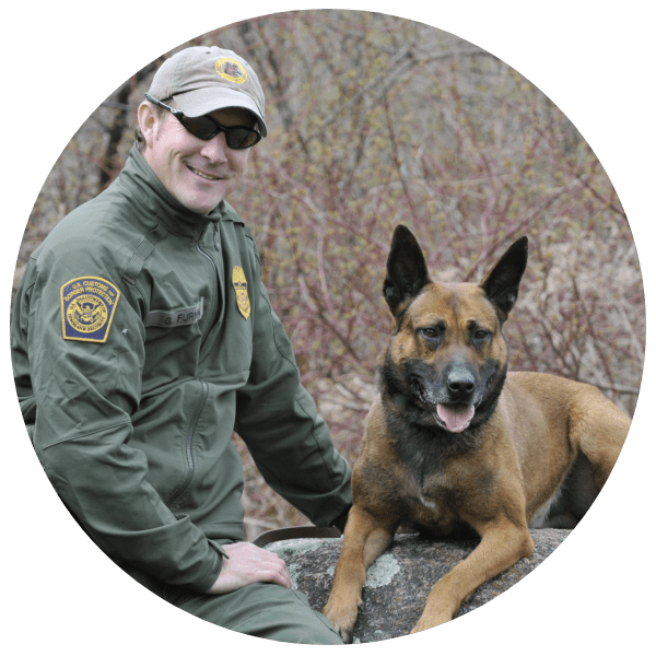 A man and his dog are sitting on the ground.