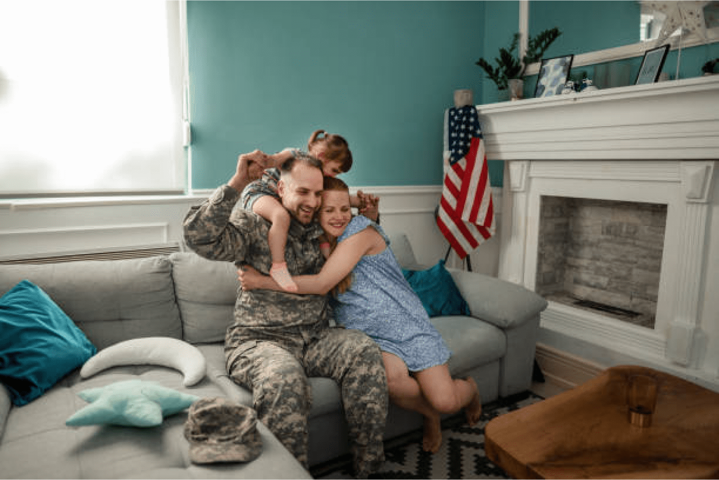 A man and two women hug on the couch.