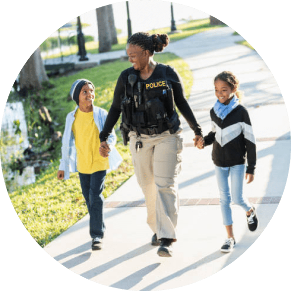 A woman and two children walking down the sidewalk.